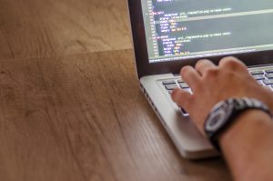 man typing code for website development