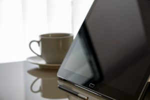 cup of coffee behind tablet